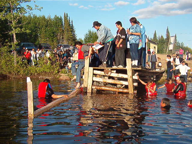 Not sure who is standing in the water, but Morris Rae, is starting to climb down onto the log.